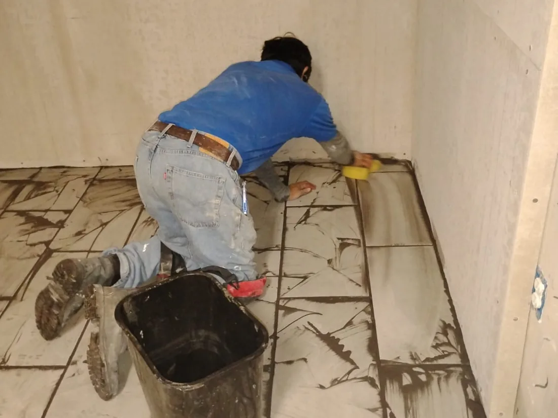 Tile being set and grouted across a floor