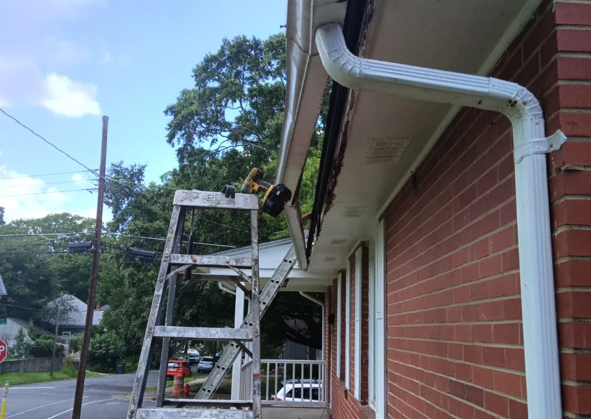 New white gutter and downspout fitted to a brick house